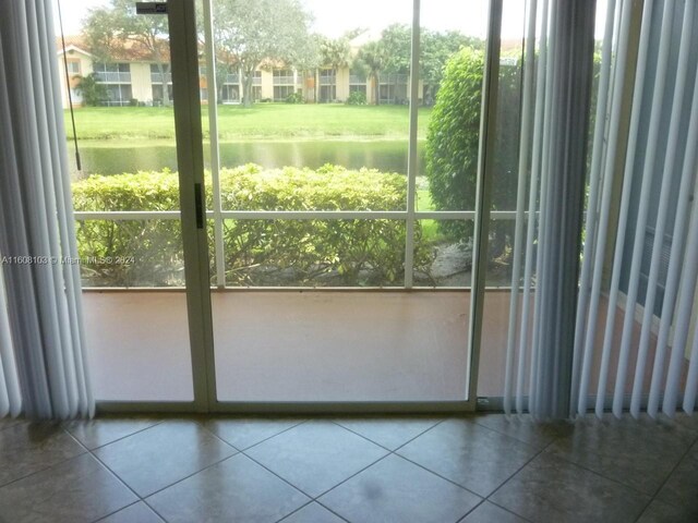 doorway featuring tile floors and a water view