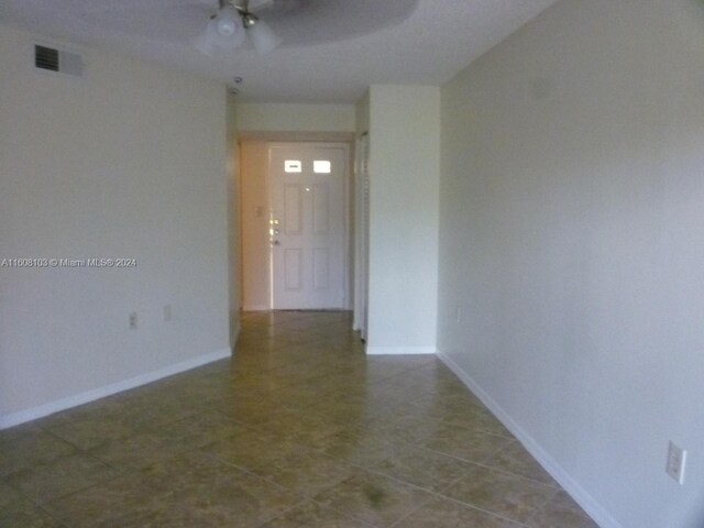 tiled empty room with ceiling fan