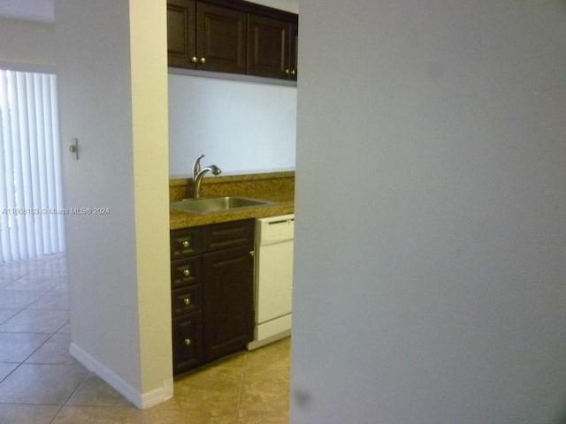 kitchen featuring sink, white appliances, dark brown cabinets, and light tile patterned floors