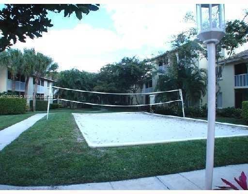 surrounding community featuring a lawn and volleyball court