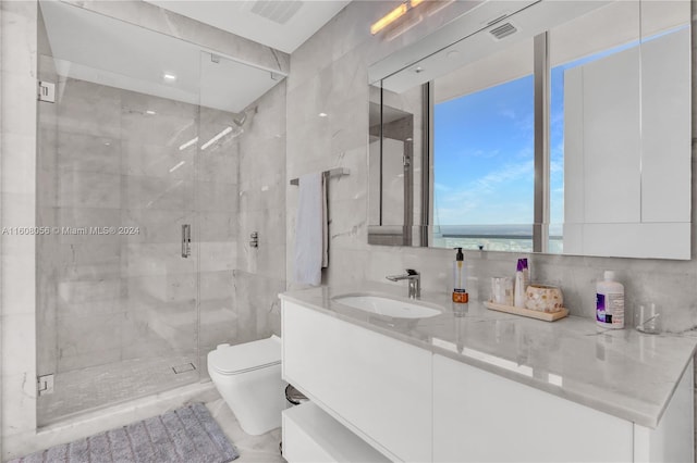 bathroom with tasteful backsplash, oversized vanity, tile walls, a shower with shower door, and toilet