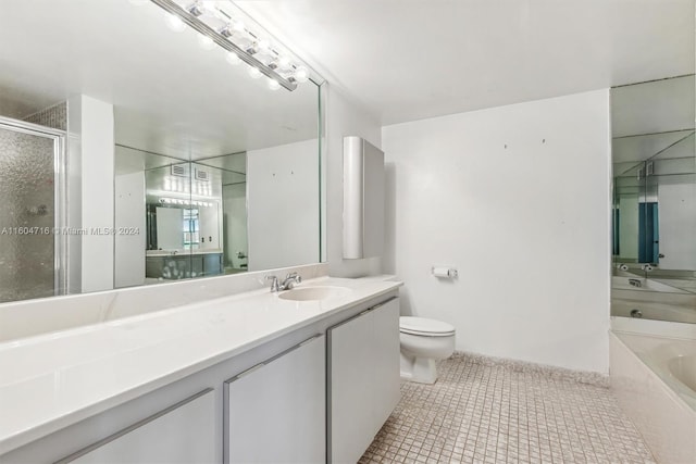 bathroom with a bath to relax in, tile floors, toilet, and vanity with extensive cabinet space