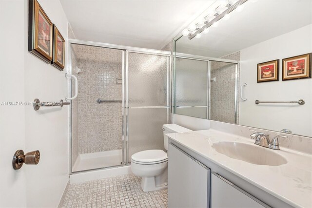 bathroom with an enclosed shower, tile flooring, toilet, and oversized vanity