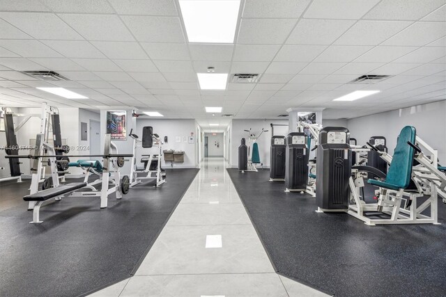 workout area with tile floors and a drop ceiling