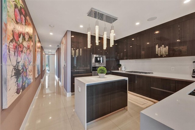 kitchen with double wall oven, light tile patterned floors, decorative light fixtures, a kitchen island, and gas cooktop