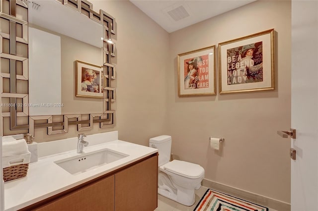 bathroom featuring tile patterned flooring, vanity, and toilet