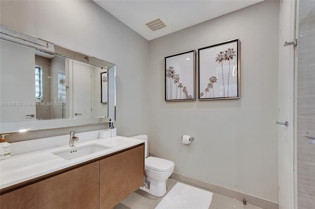 bathroom with tile patterned flooring, vanity, and toilet