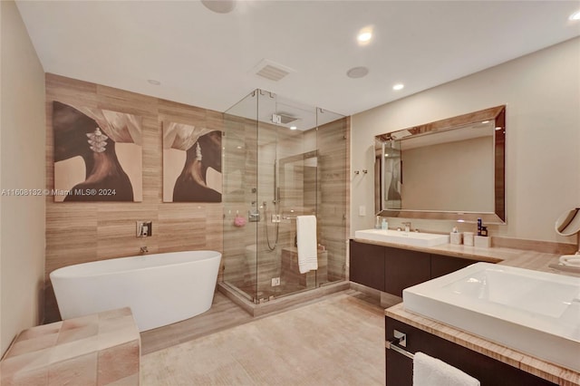 bathroom with vanity, tile walls, and plus walk in shower