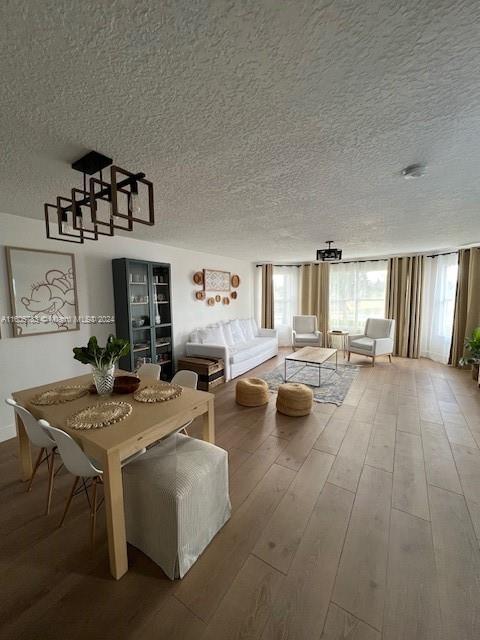 unfurnished dining area featuring hardwood / wood-style floors and a textured ceiling