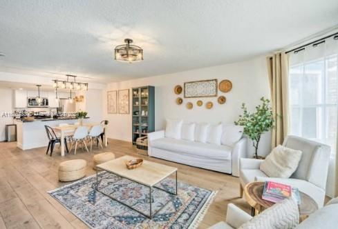 living room with a notable chandelier and light wood-type flooring