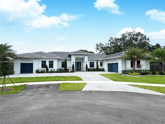 view of front of home with a front yard and a garage