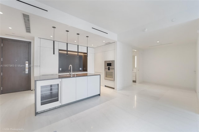 kitchen featuring light tile floors, white cabinets, pendant lighting, and appliances with stainless steel finishes