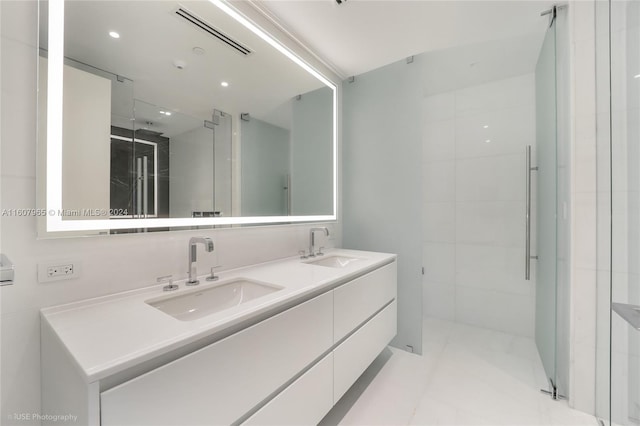 bathroom featuring tile flooring, tile walls, oversized vanity, and double sink