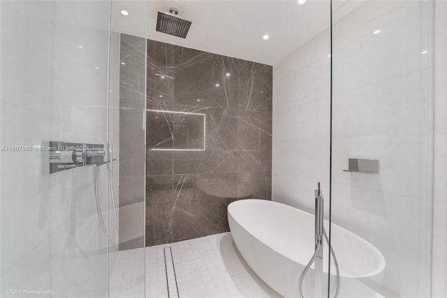 bathroom with walk in shower and tile walls