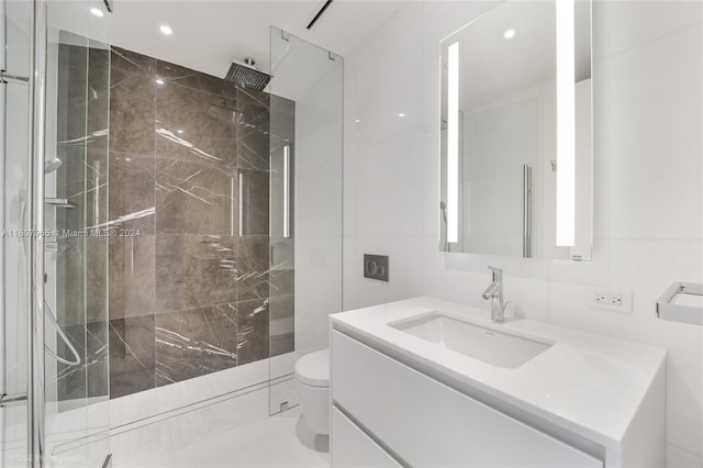 bathroom with tile walls, an enclosed shower, toilet, and vanity