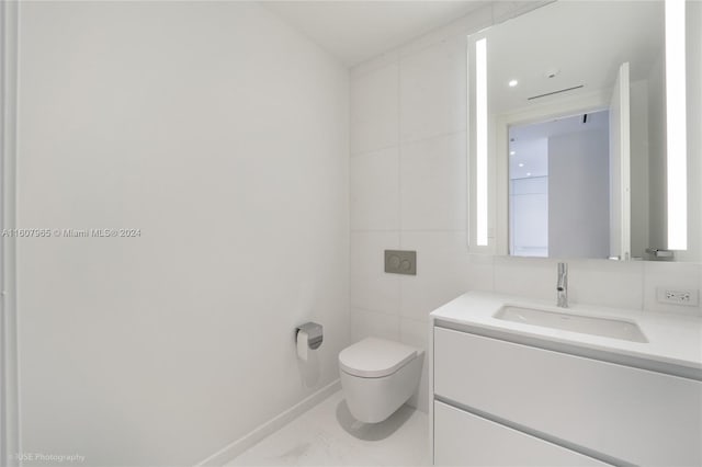 bathroom with tile floors, oversized vanity, toilet, and tile walls