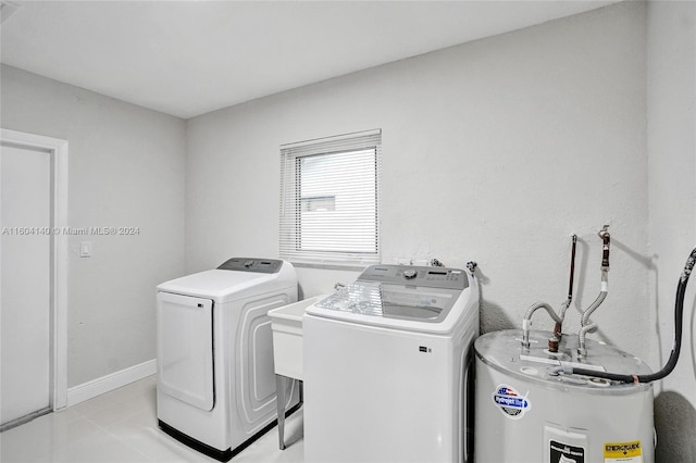 washroom with light tile patterned flooring, washer and dryer, and water heater