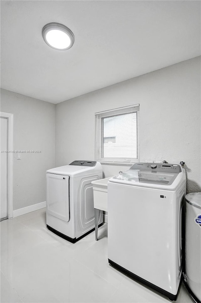 laundry room featuring washing machine and dryer and light tile patterned flooring