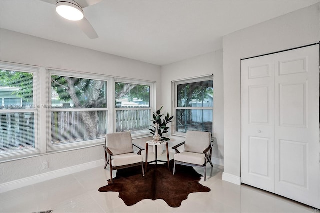 living area featuring tile patterned floors and ceiling fan