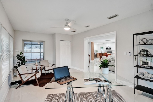 home office featuring light tile patterned floors and ceiling fan