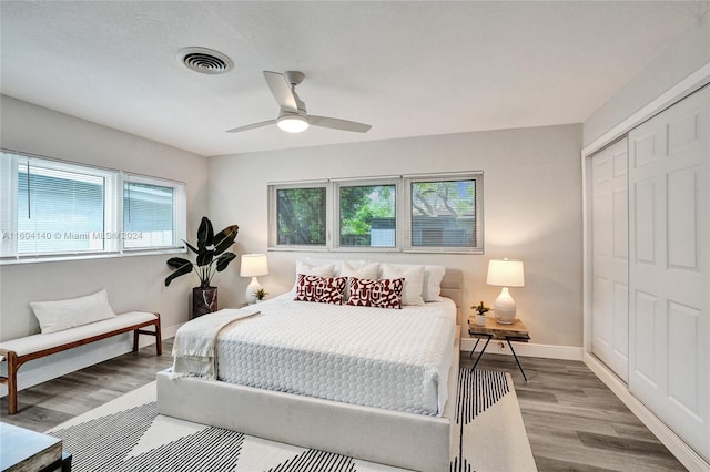 bedroom featuring a closet, light hardwood / wood-style flooring, and ceiling fan