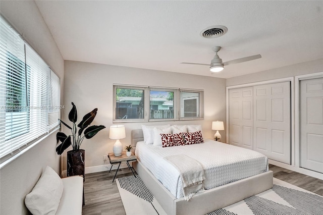 bedroom with light hardwood / wood-style floors, multiple windows, and ceiling fan