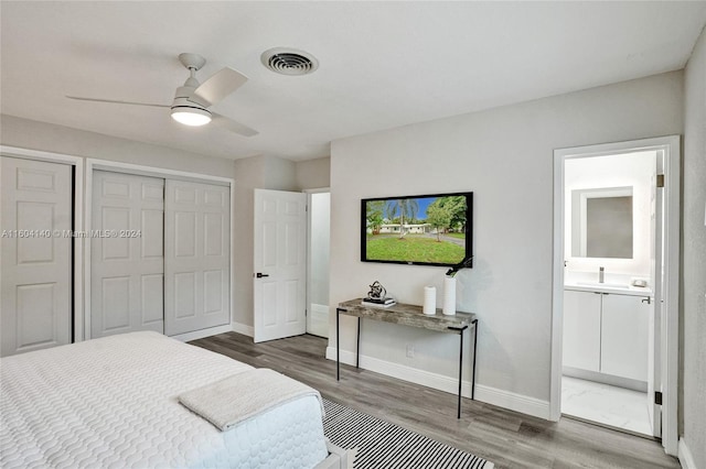 bedroom featuring hardwood / wood-style flooring, ceiling fan, and connected bathroom