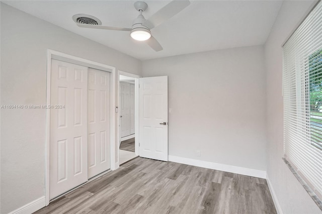 unfurnished bedroom with a closet, light hardwood / wood-style flooring, and ceiling fan