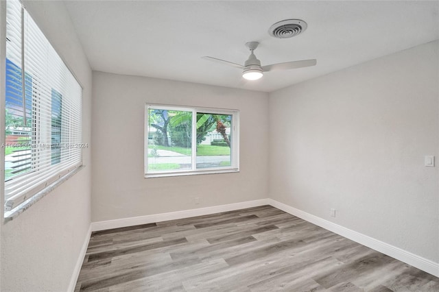 spare room with ceiling fan and light wood-type flooring