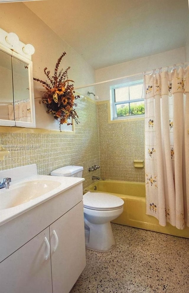 full bathroom featuring shower / bath combo, tasteful backsplash, toilet, vanity, and tile walls