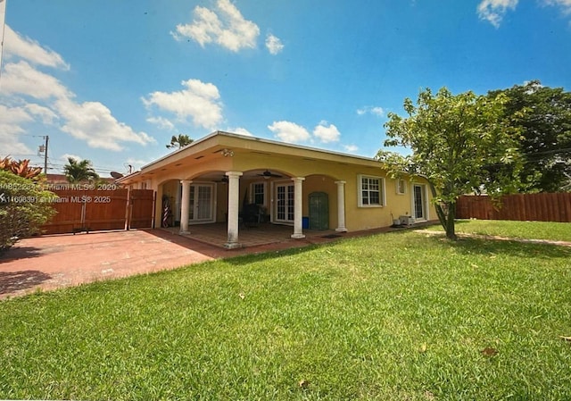 rear view of house featuring a patio, ceiling fan, and a lawn