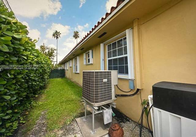 view of property exterior with a lawn and cooling unit