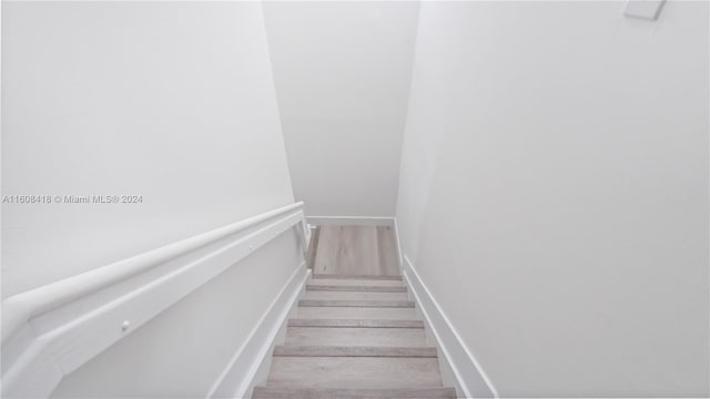 stairs featuring hardwood / wood-style floors