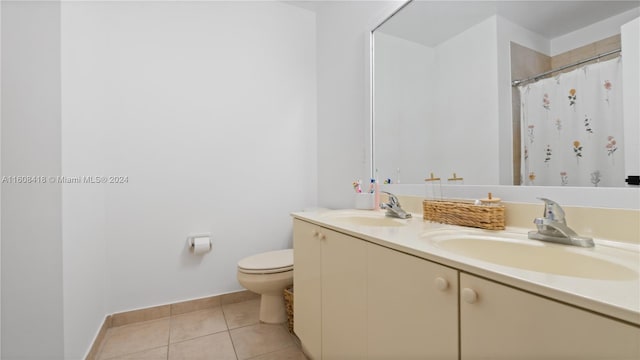 bathroom with double vanity, tile patterned flooring, and toilet