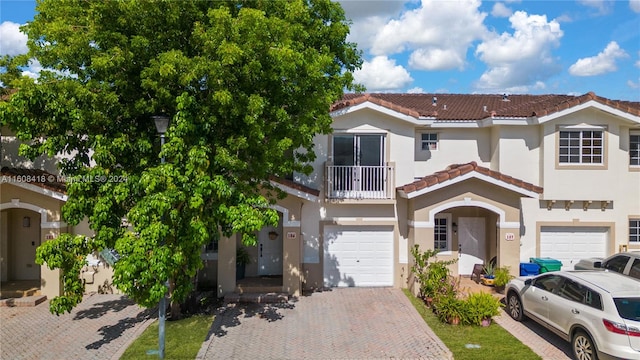 view of front of property featuring a garage and a balcony