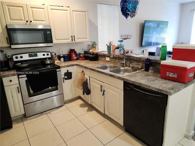 kitchen featuring white cabinets, sink, light tile patterned floors, appliances with stainless steel finishes, and kitchen peninsula