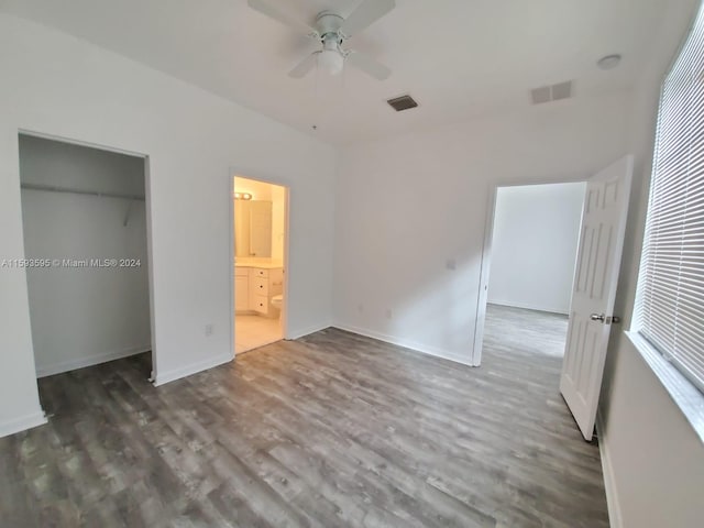 unfurnished bedroom with ceiling fan, a closet, ensuite bathroom, and dark hardwood / wood-style floors