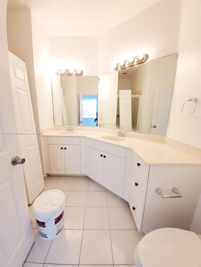 bathroom with tile patterned flooring, vanity, a shower with door, and toilet