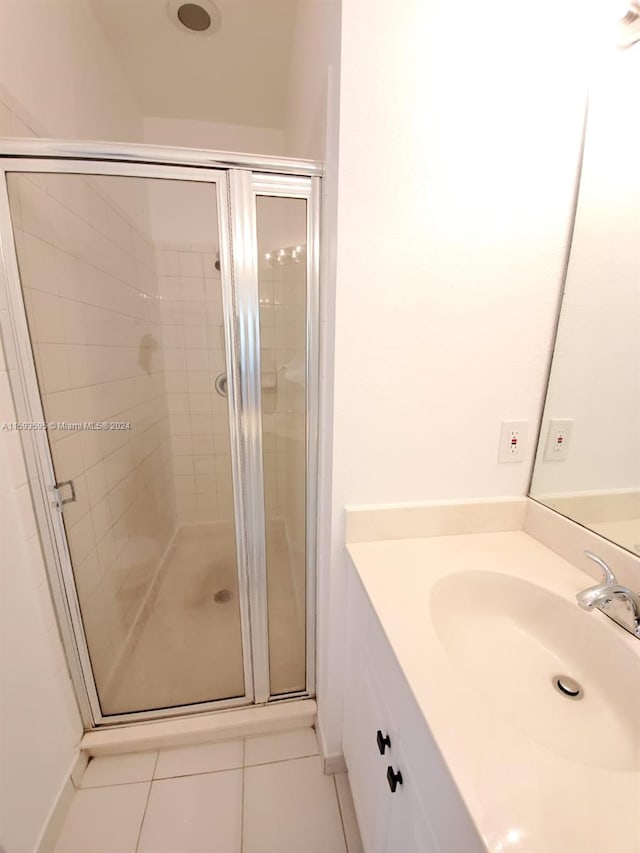 bathroom with tile patterned floors, a shower with door, and vanity