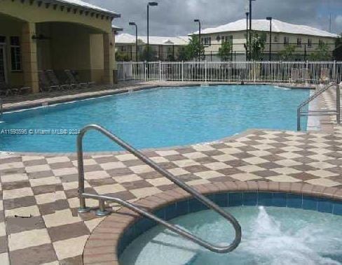 view of swimming pool with a community hot tub