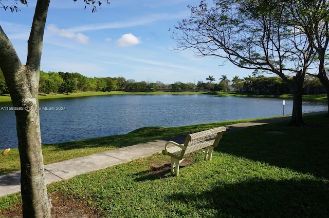 view of property's community with a yard and a water view