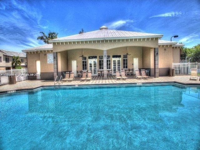 pool with ceiling fan, fence, french doors, and a patio
