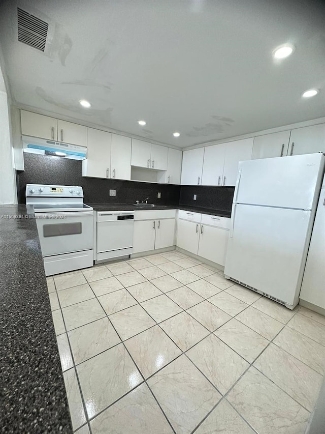 kitchen featuring tasteful backsplash, white cabinetry, sink, dark stone counters, and white appliances