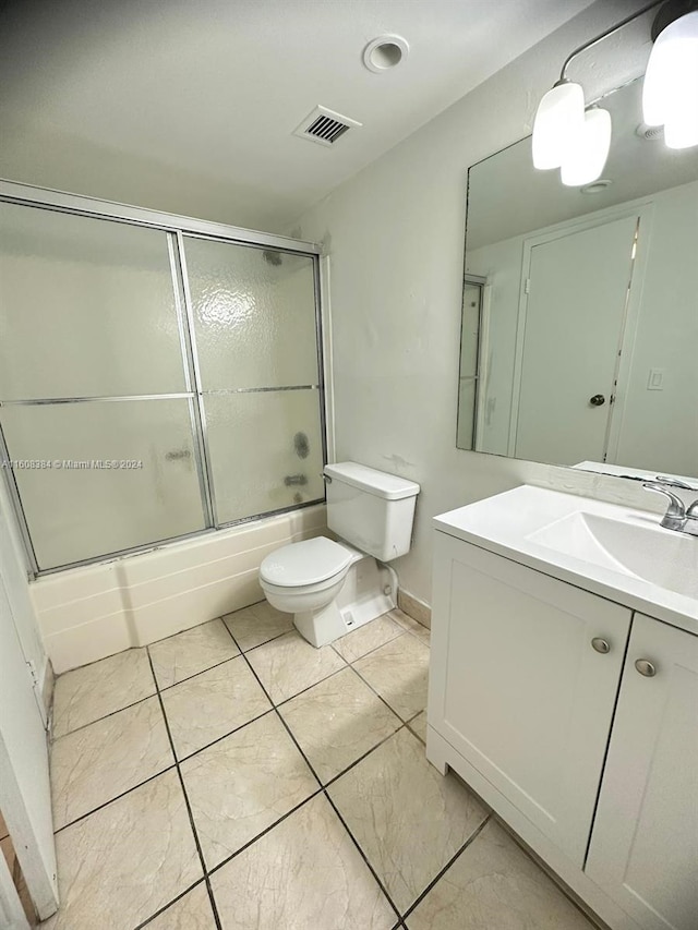 full bathroom with tile patterned flooring, vanity, shower / bath combination with glass door, and toilet