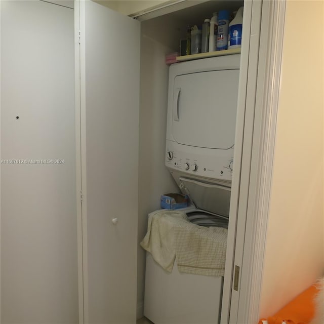 washroom featuring stacked washer and clothes dryer