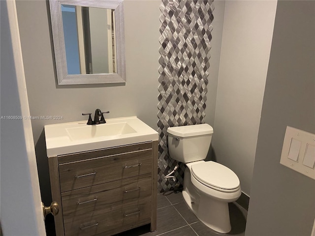 bathroom with tile patterned flooring, vanity, and toilet