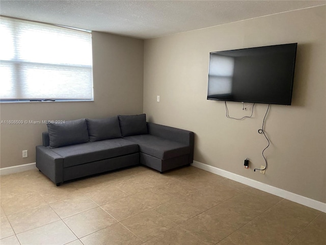 living room with a textured ceiling and light tile patterned floors