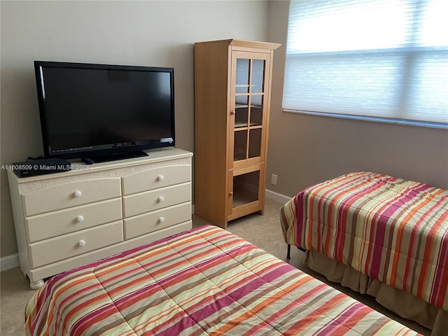 carpeted bedroom featuring multiple windows