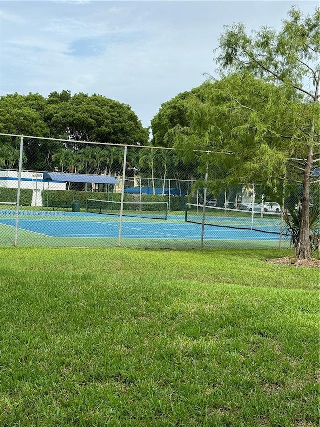 view of sport court featuring a lawn