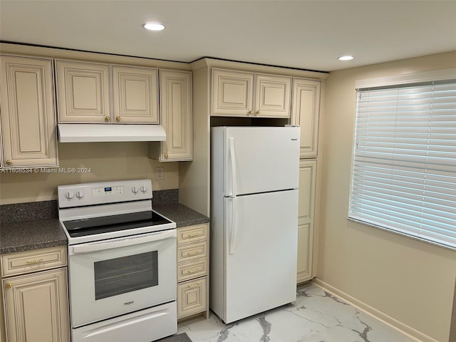 kitchen with cream cabinetry and white appliances